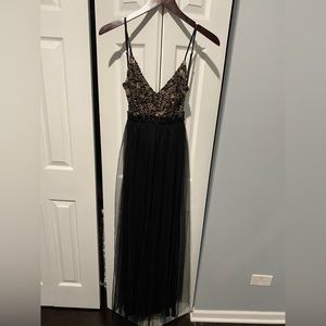 Open back black and gold gown with double slit under sheer material